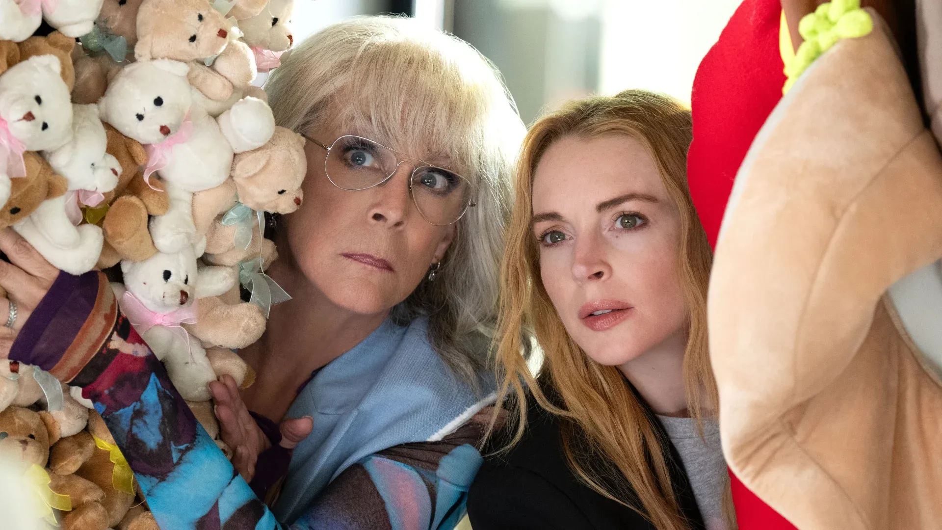 Jamie Lee Curtis and Lindsey Lohan spying through a pile of teddy bears in the film Freakier Friday.